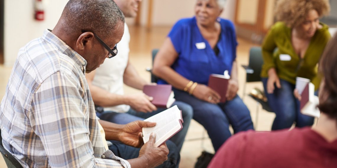 People Attending Bible Study Or Book Group Meeting In Community Center