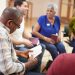 People Attending Bible Study Or Book Group Meeting In Community Center