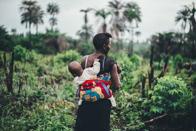 african woman carrying baby on back
