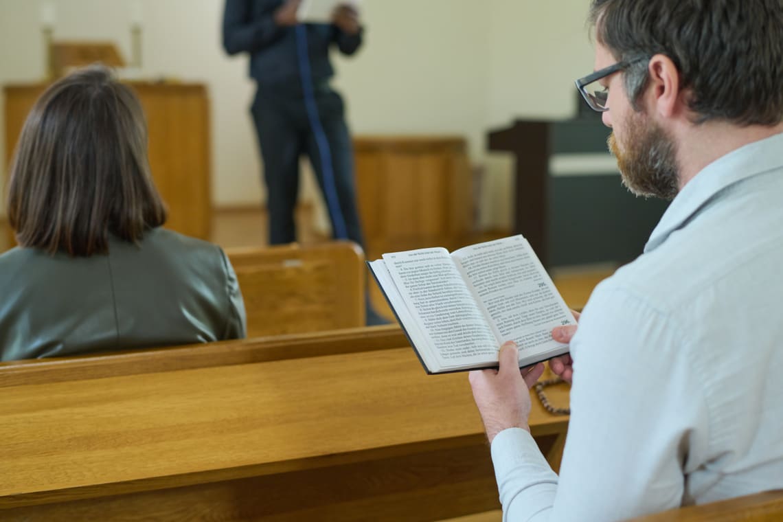 middle-aged-man-with-open-holy-bible-reading-in-church