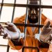 they are hid in prison houses kjv - african-american-prisoner-in-handcuffs