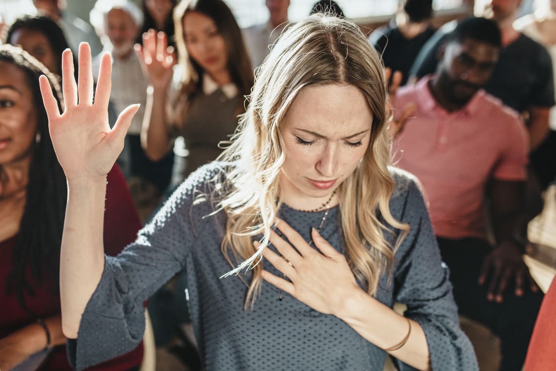 white-woman-raising-her-hand-in-church